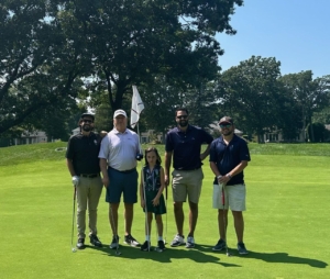 Photo shows Ralph Lambert and rest of the foursome on a golf green